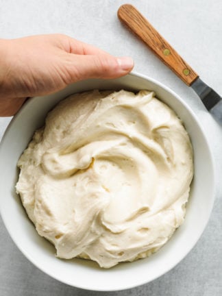 holding a bowl of Cream Cheese Mascarpone Frosting