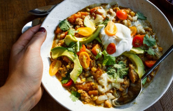 holding a bowl of Butternut Squash Hatch Green Chili