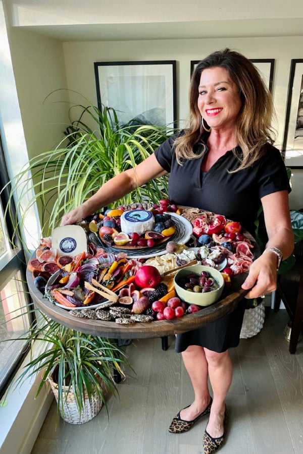 woman holding an epic holiday cheese board