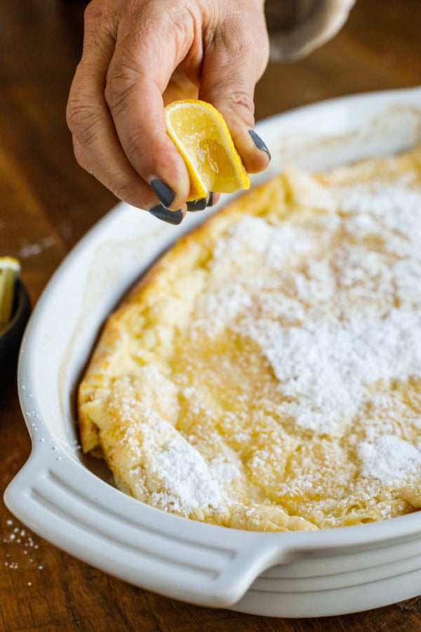 squeezing lemon on German Pancake (Dutch Baby) 