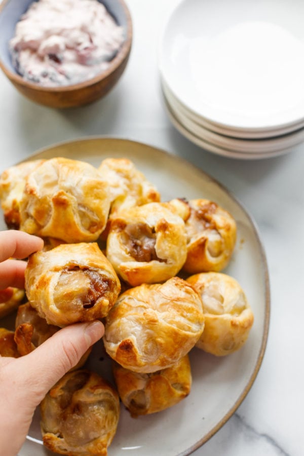 taking bite of Mini Sausage Onion Brie en Croute