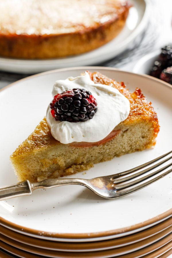 a piece of Almond Pear Upside Down Cake with whipped cream