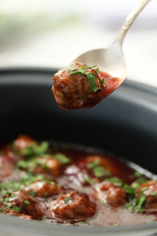 taking bite of cocktail meatballs