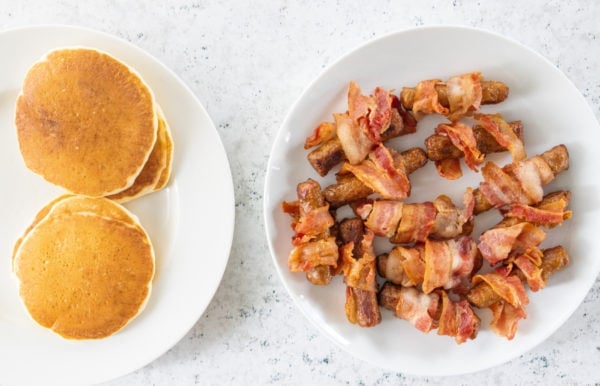 plates of pancakes and sausage with bacon