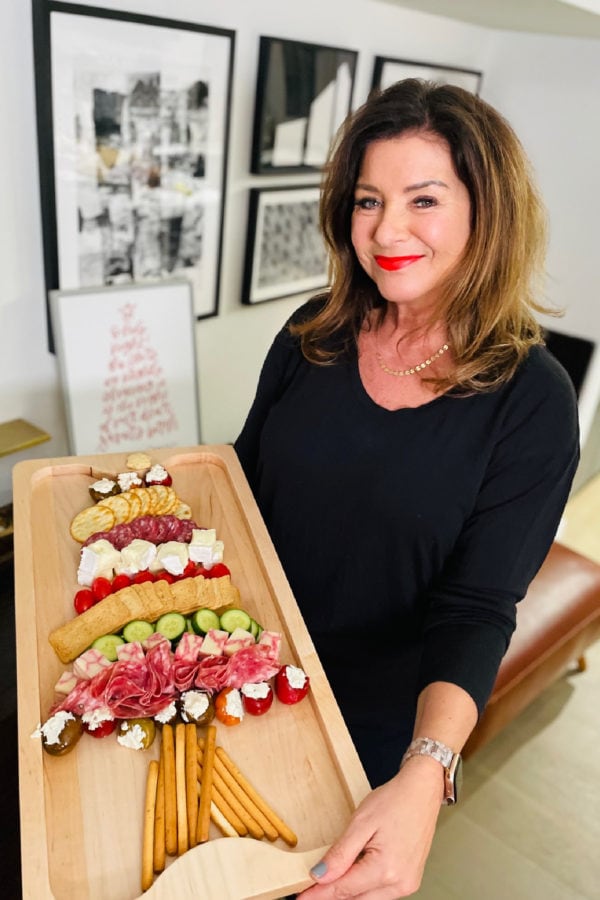 woman holding a christmas tree charcuterie board