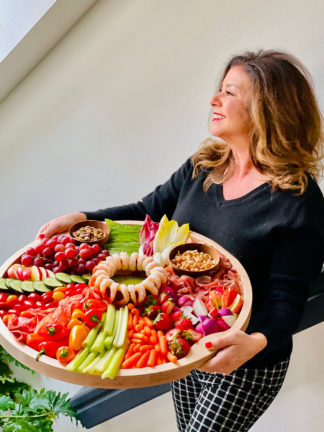 holding a vibrant Whole 30 Charcuterie Board