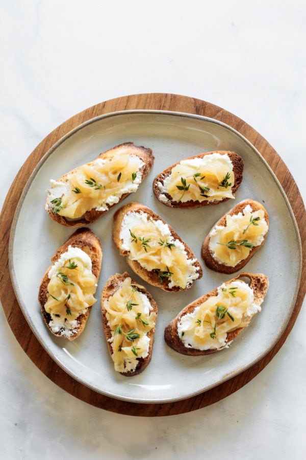 round plate of bite of Caramelized Onion Crostini