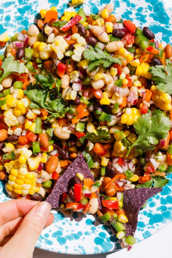 taking a bite of Texas Caviar Bean Dip