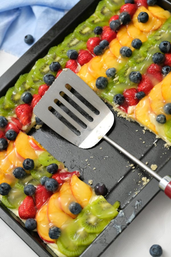 spatula in pan of fruit pizza