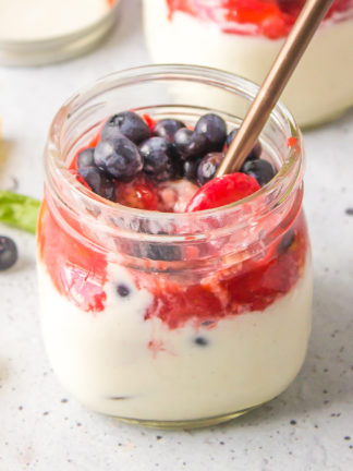 a spoon in a jar of Strawberry Blueberry Panna Cotta