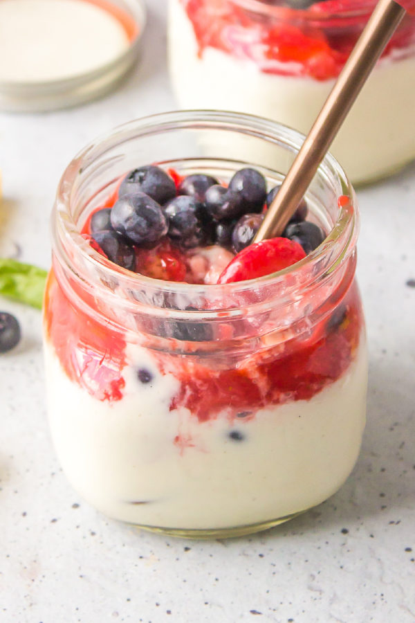 a spoon in a jar of Strawberry Blueberry Panna Cotta