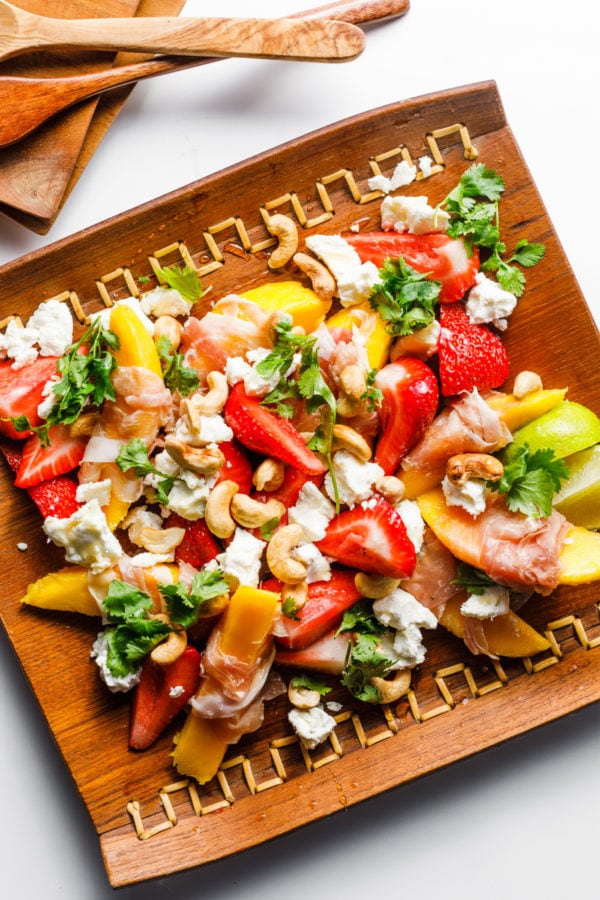 wood plate of Prosciutto Wrapped Mango Salad