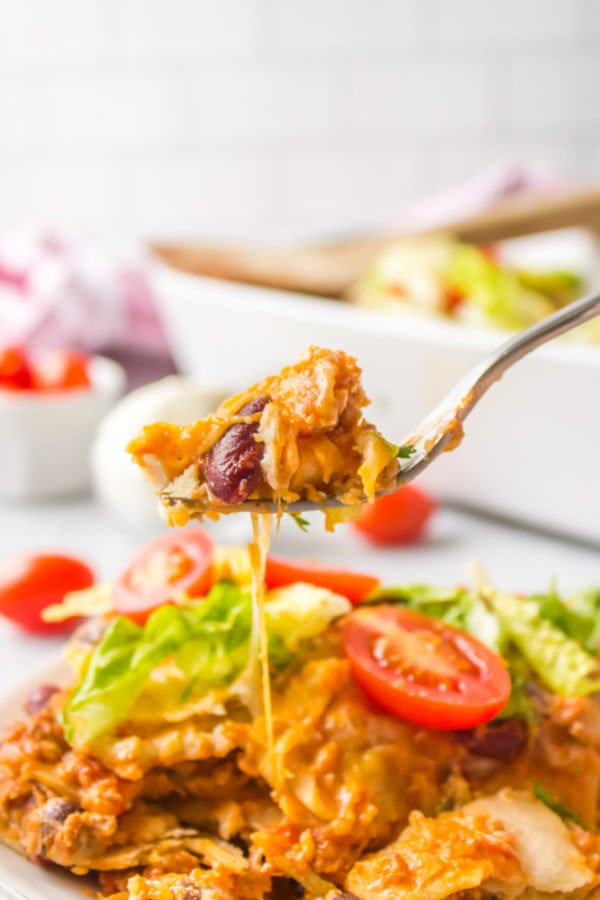 taking a bite of Cake Pan Layered Enchilada Bake