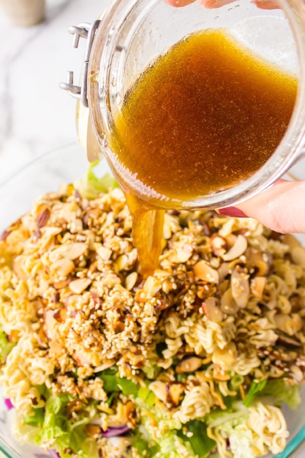 pouring dressing over the ramen noodles