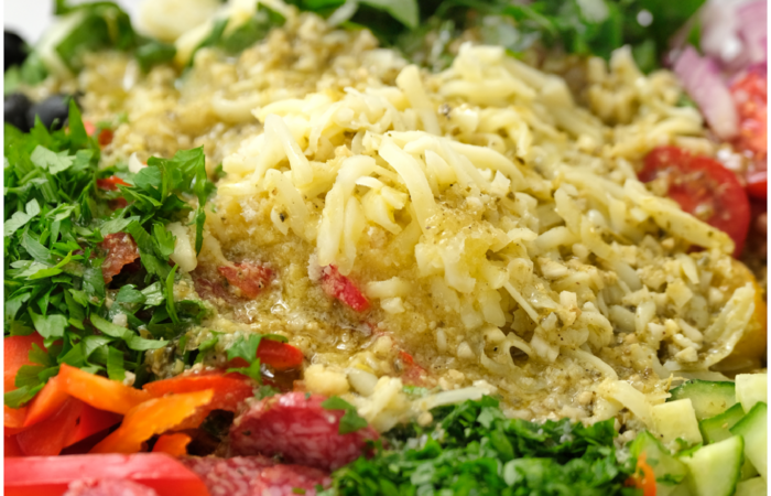 adding dressing to a pasta salad