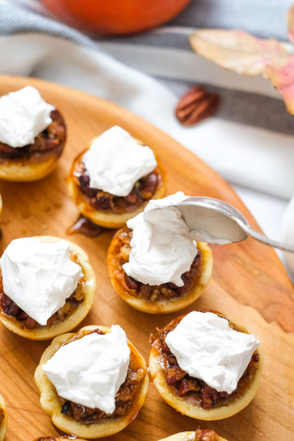 spooning whipped cream on a tart