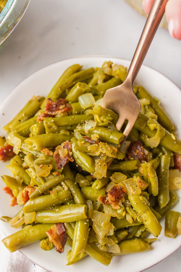 taking a bite of Green Beans with Bacon and Onions