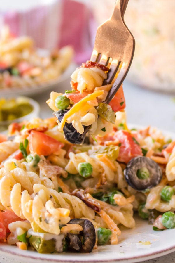 taking a bite of pasta salad with bacon