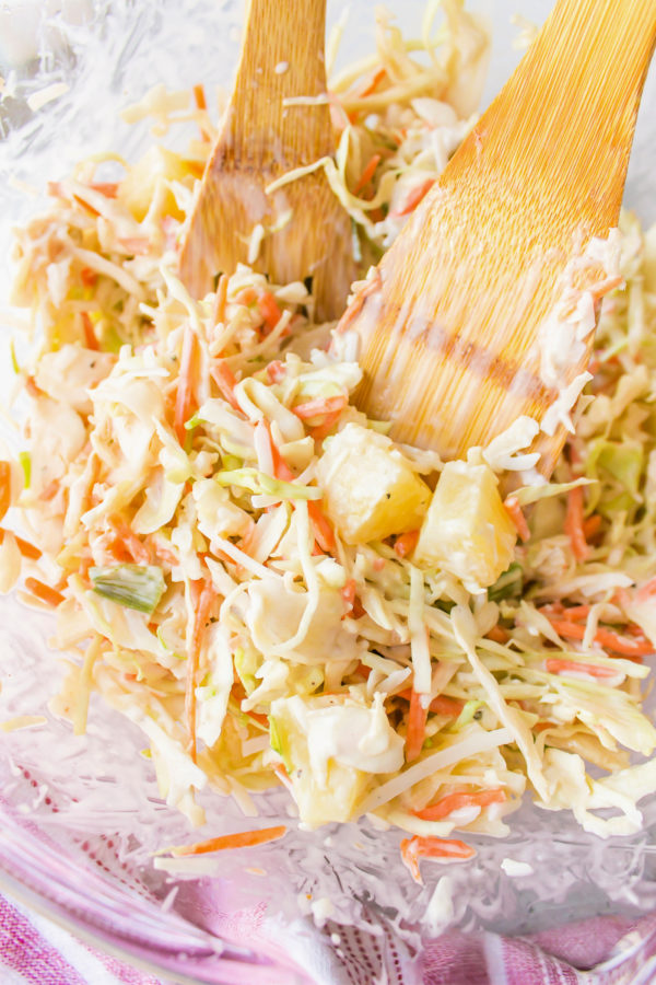 mixing coleslaw with wooden spoon