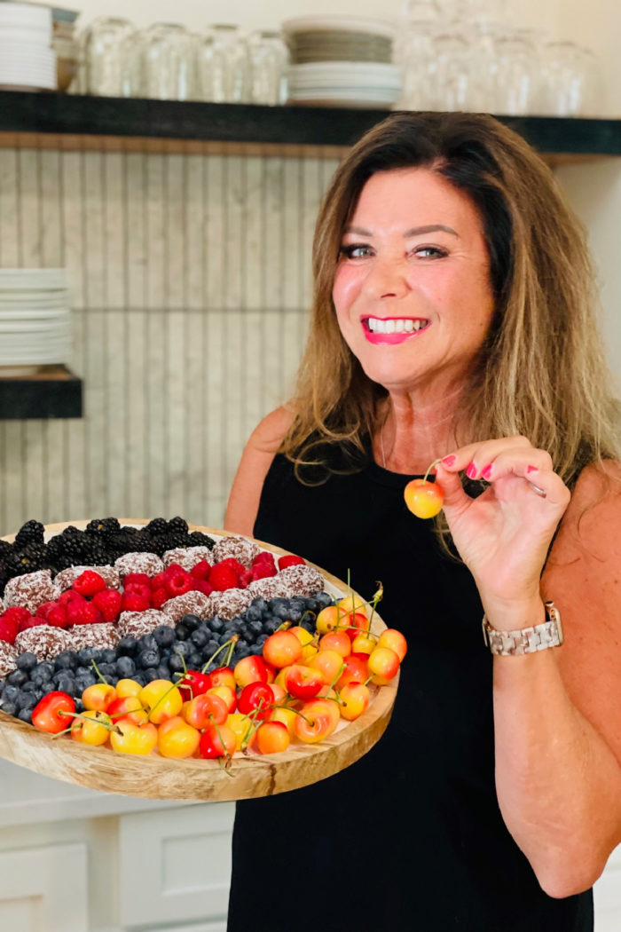 woman holidng a cherry and fruit tray