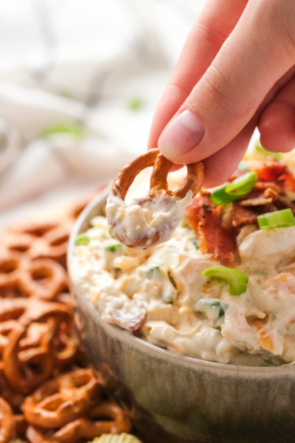 dipping a pretzel in creamy dips