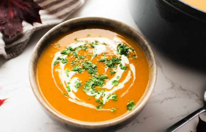 a bowl of pumpkin soup with creme fraiche