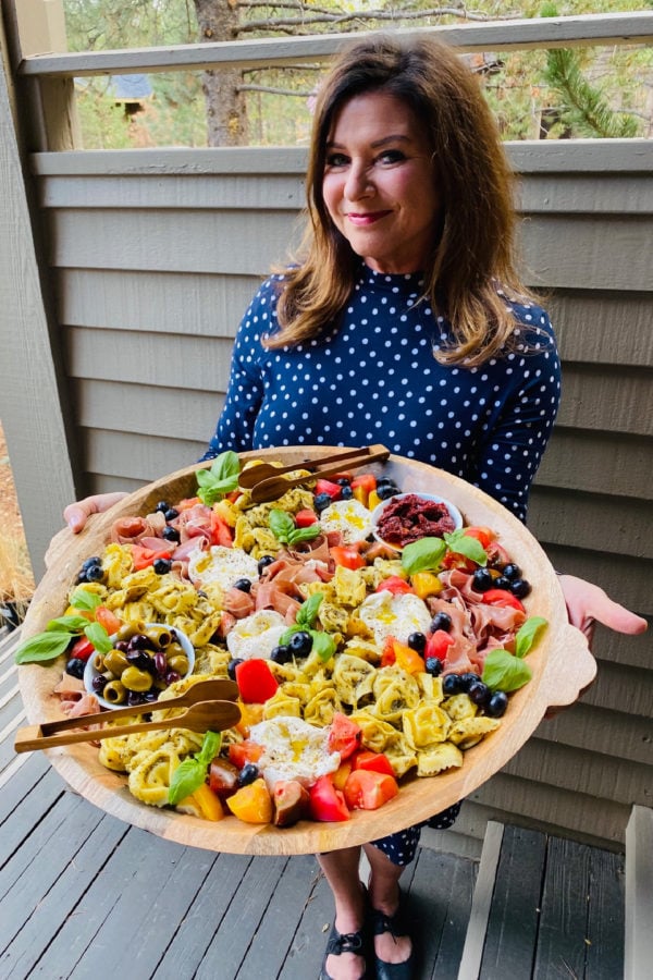 woman holding a Tuscan Tortellini Salad board