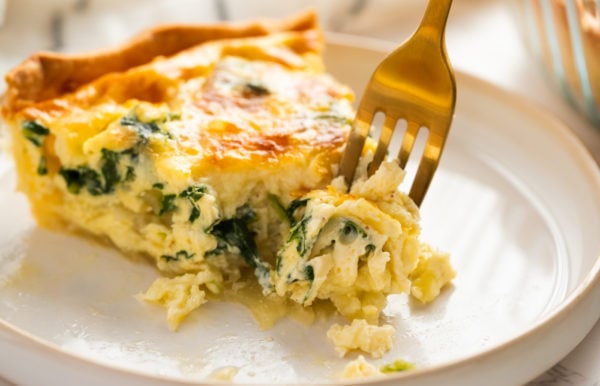 taking a bite of cheesy quiche