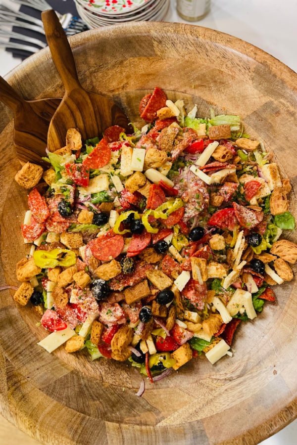 a Pizza Salad with wood salad tongs