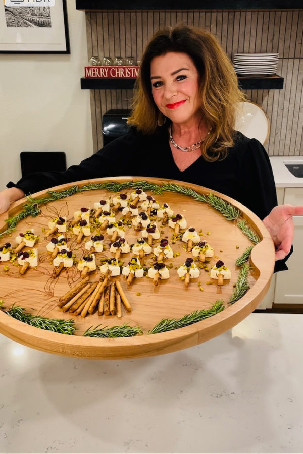 woman holding a cheese board