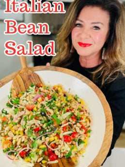 woman holding an epic salad bowl of Italian Bean Salad