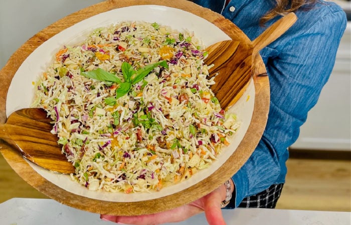 coleslaw in large bowl with wood paddles