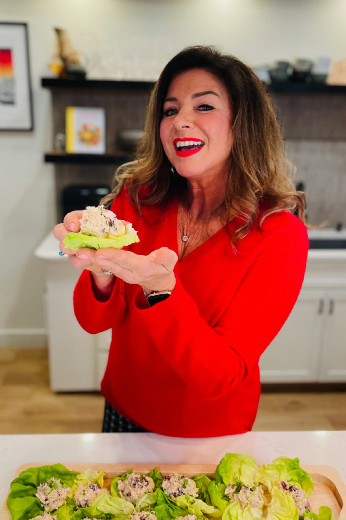 woman holding a tuna salad apple slice