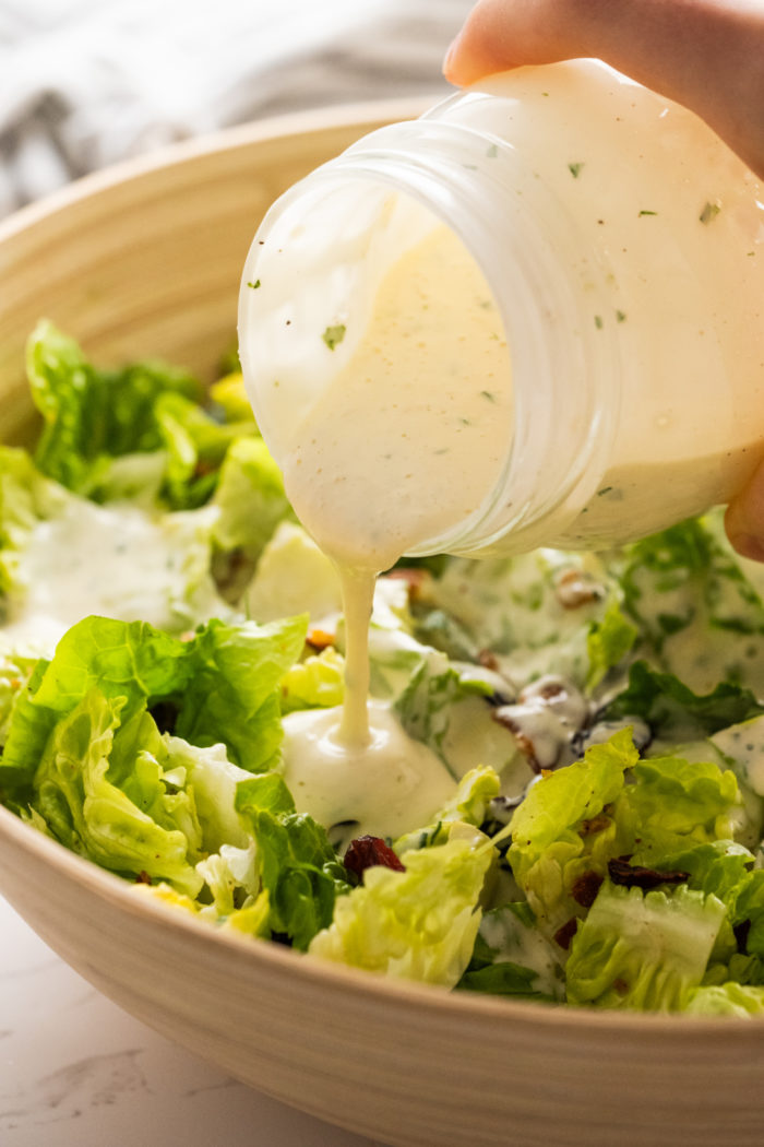 pouring Pineapple Dressing over lettuce