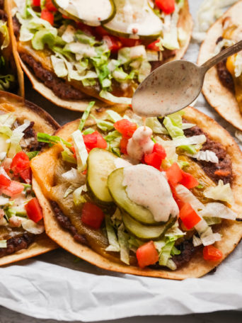 adding burger sauce to a burger taco