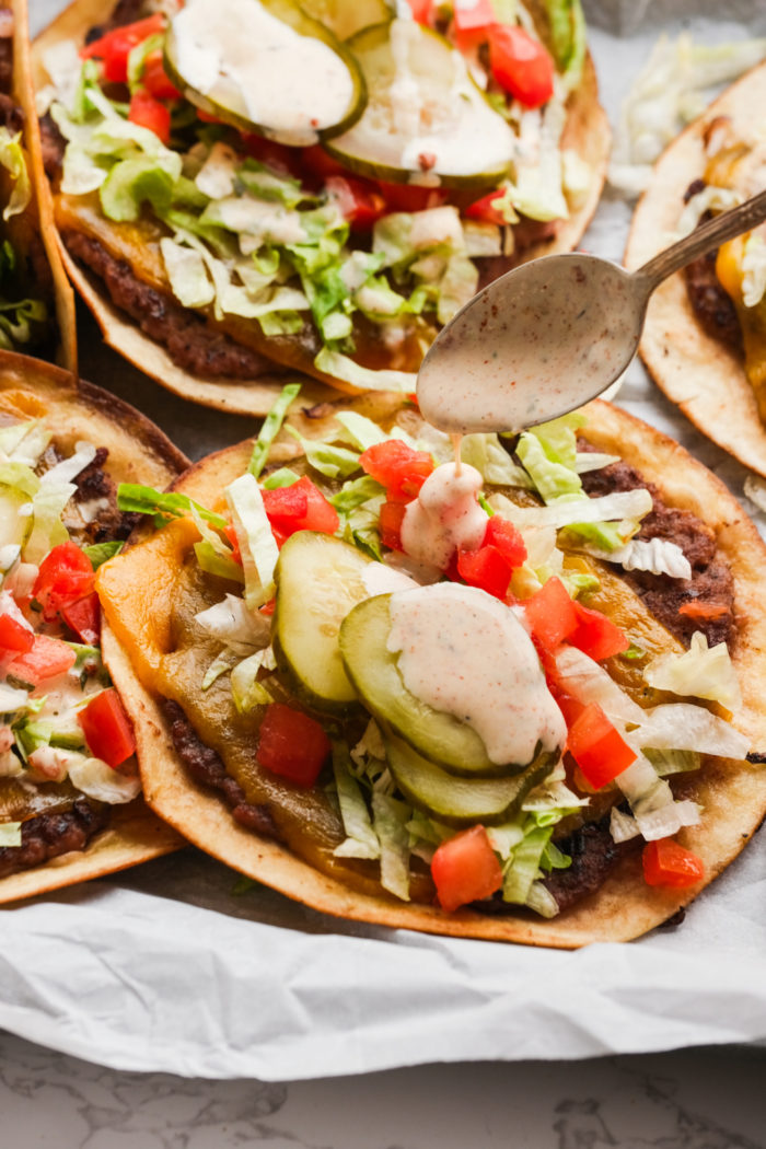 adding burger sauce to a burger taco