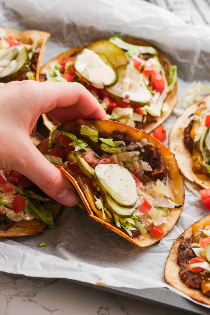 taking a bite of burger tacos