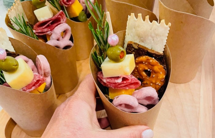 meat, cheese, crackers, olives in cups
