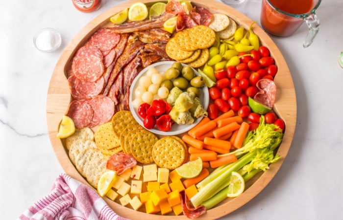 a round bloody mary charcuterie drinks board