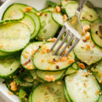 taking a bite of cucumber salad