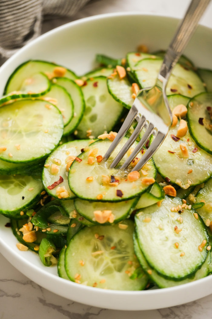 taking a bite of cucumber salad