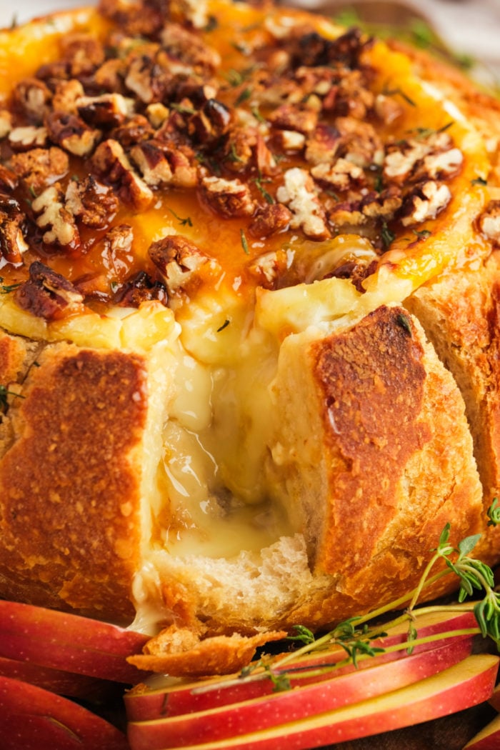 taking a bite of bread in Baked Brie Bread Bowl