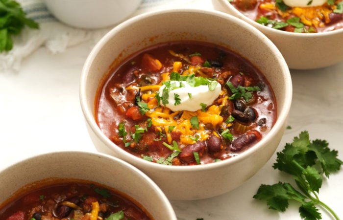 dab of sour cream on a bowl of chili and beans