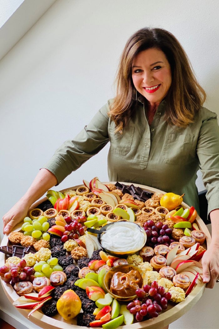 a woman holding an epic fall dessert board