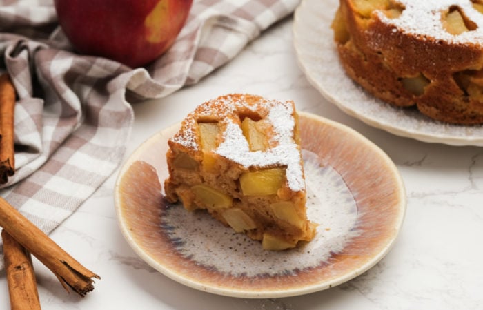 a piece of cake with apples and dusting of powdered sugar