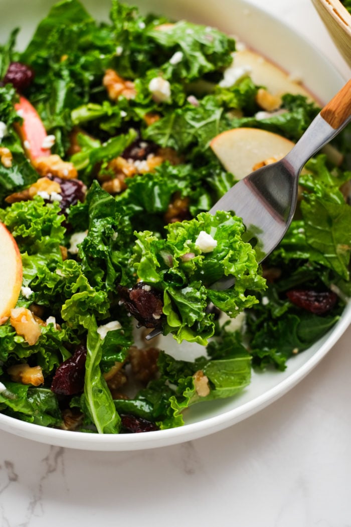 taking a bite of kale salad