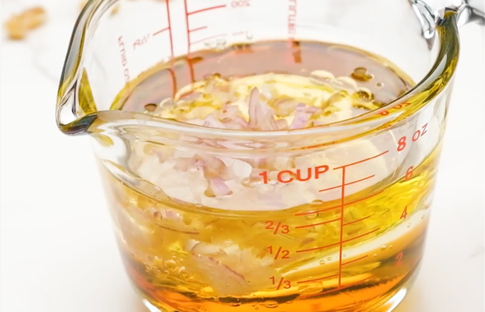 mixing a walnut oil dressing with shallots and maple