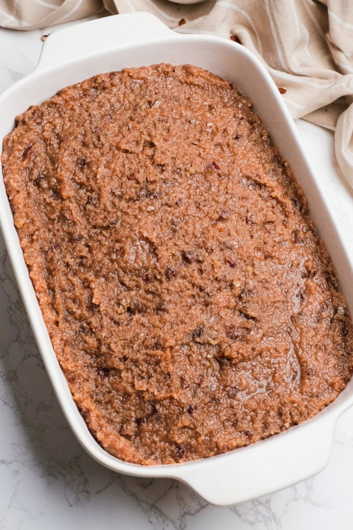 spreading on coconut frosting on cocktail cake