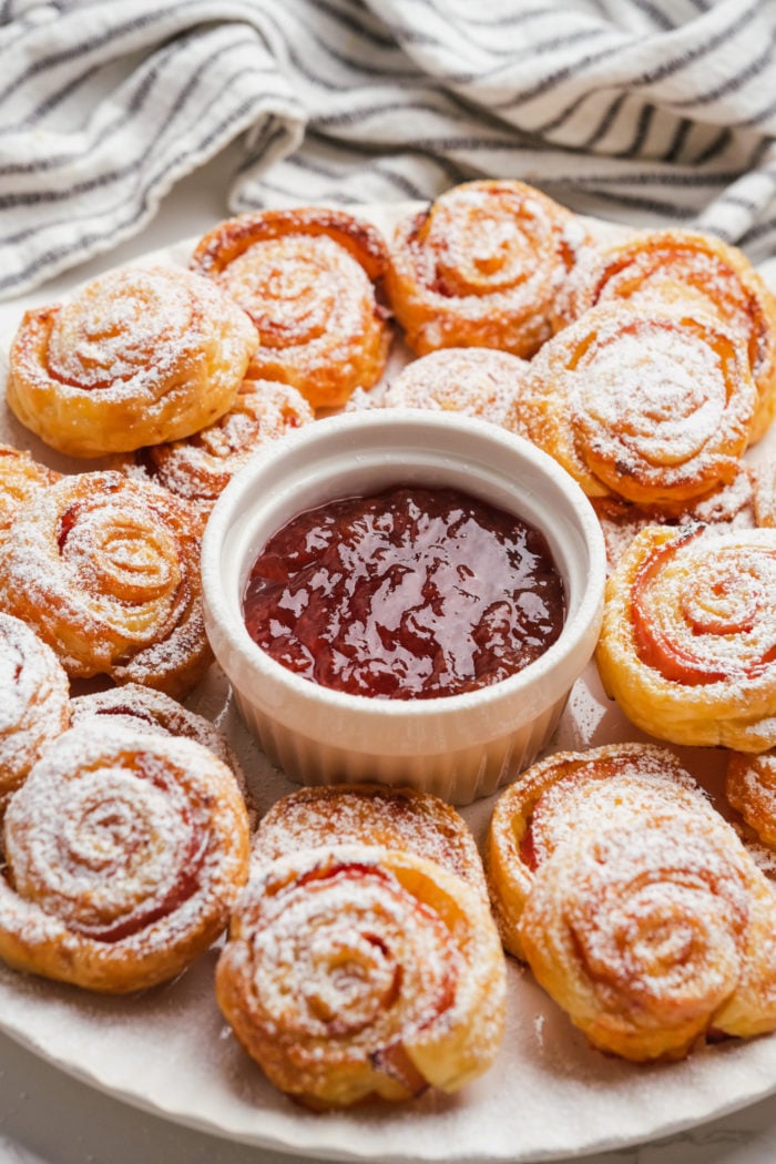 pinwheel with powdered sugar and jam on serving plate