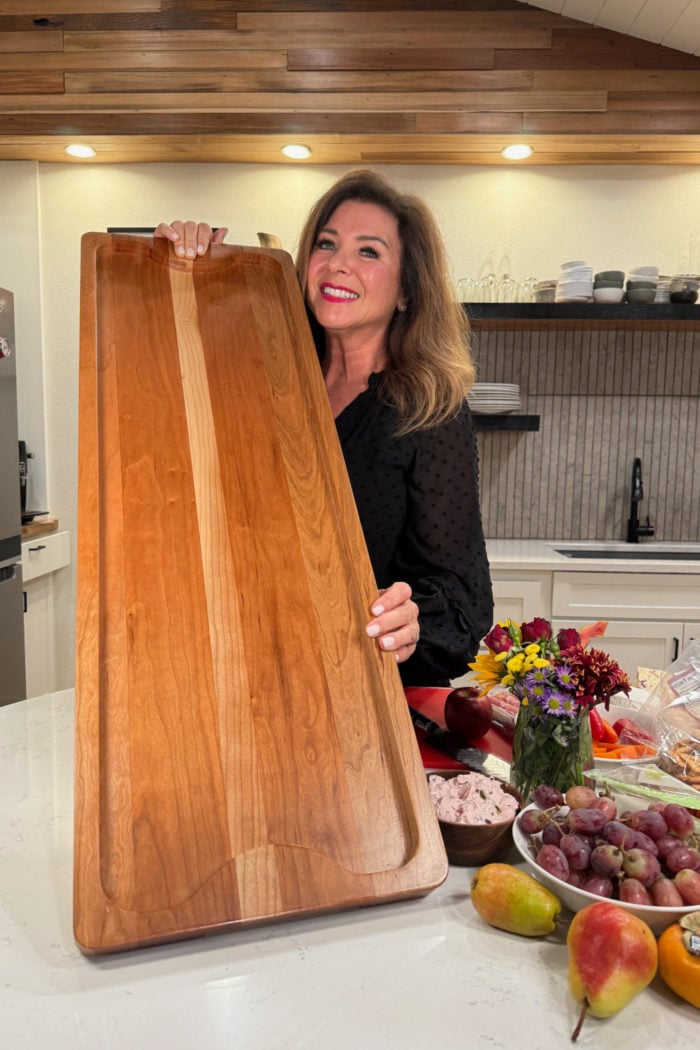 holding a large board for charcuterie